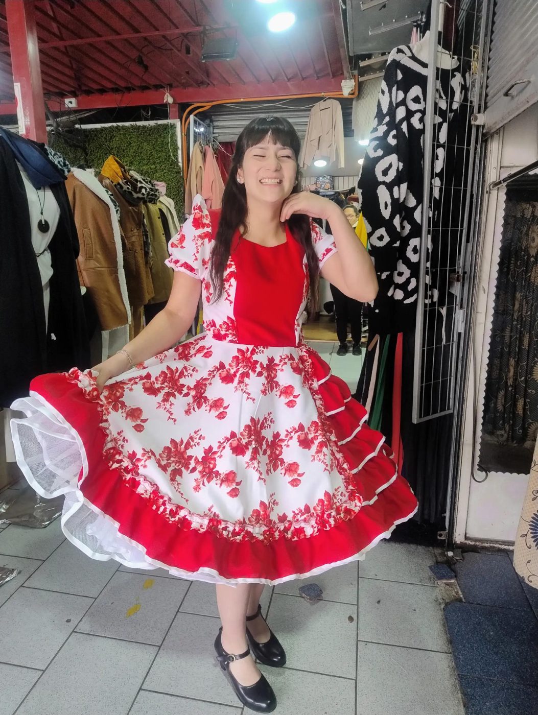 China con vestido floreado rojo y blanco en el local