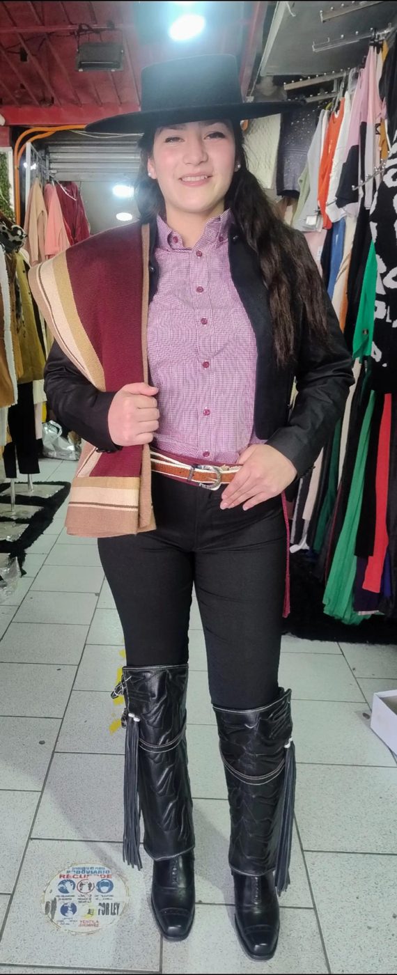 Huasa corralera con blusa rosada, manta y botas altas