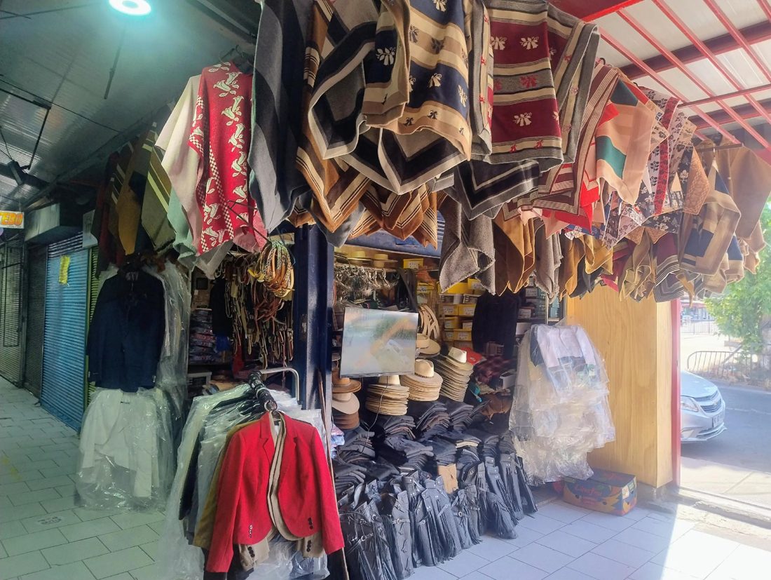 Mantas de colores, chaquetas y camisas en el pasillo del local