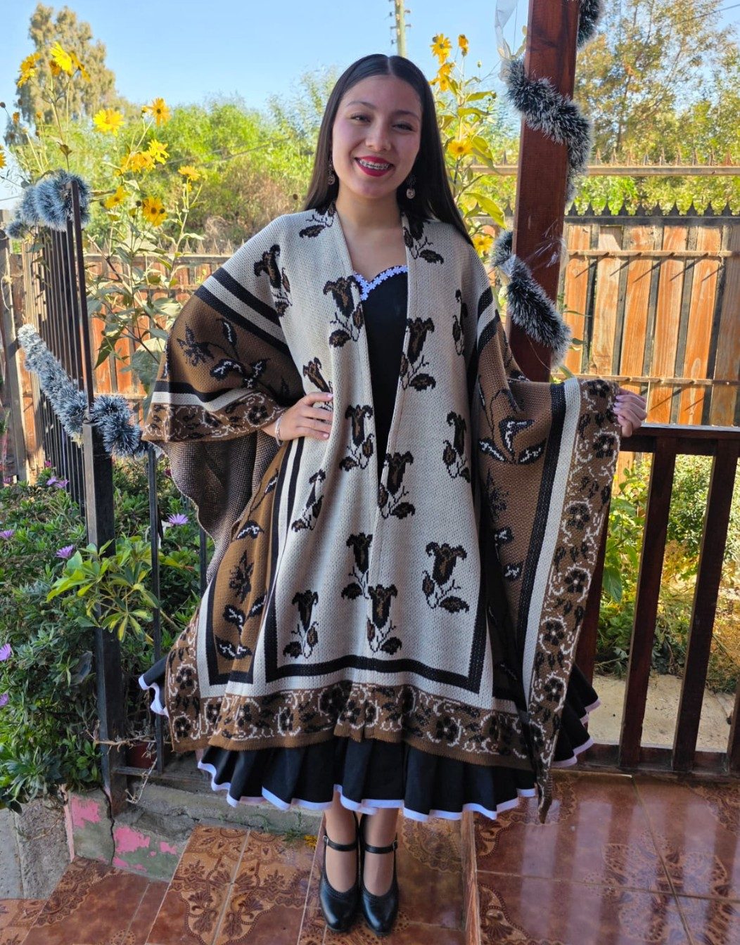 Huasa con manta de diseño en tonos crudos sobre el vestido de china